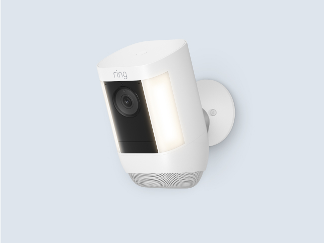 A white Spotlight Cam Pro Battery with built-in LED lights, security camera, and circular mounting base.