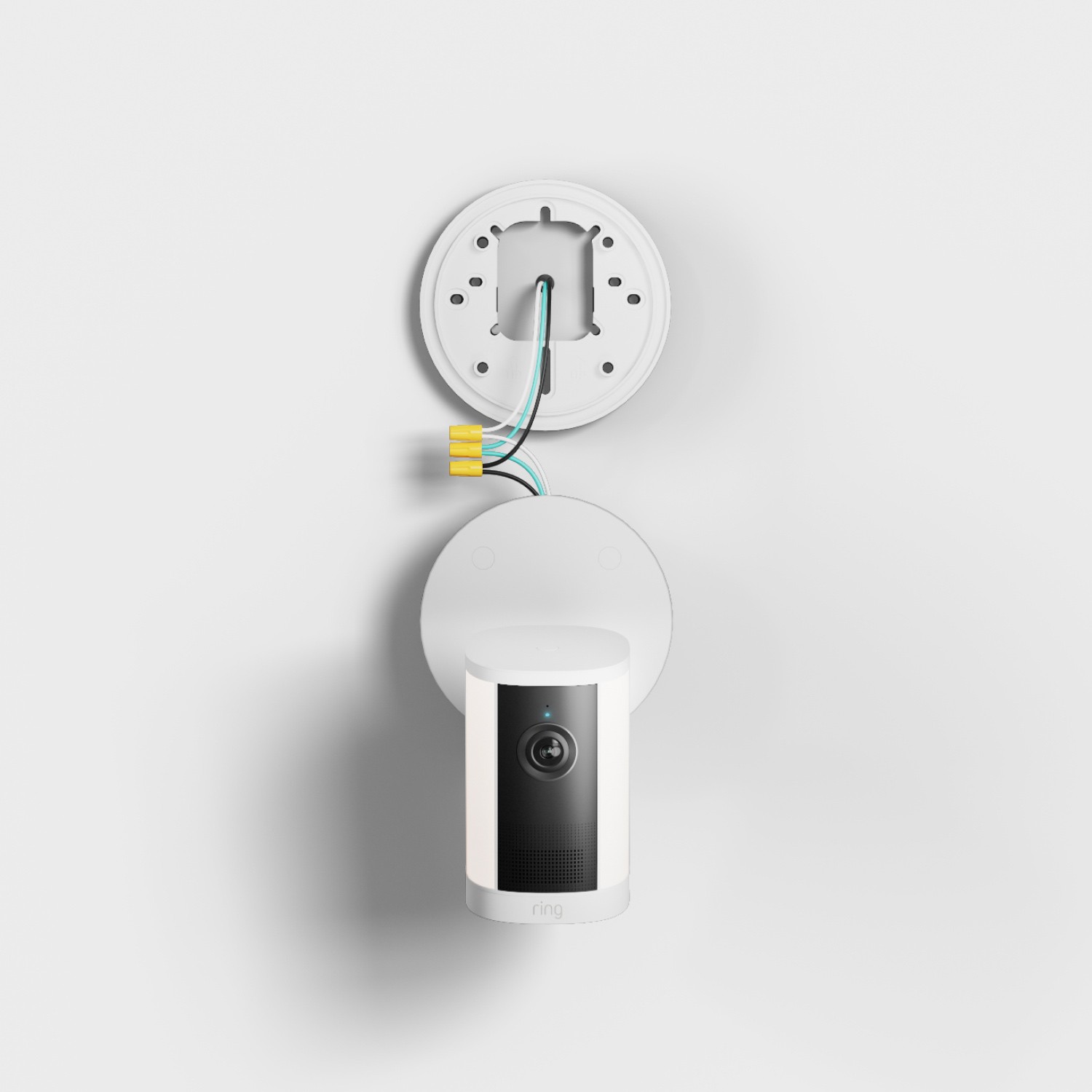 Spotlight Cam 4K Plus - Wired:White indoor camera mounted on a wall plate, with exposed wiring and wire nuts shown above for installation context.