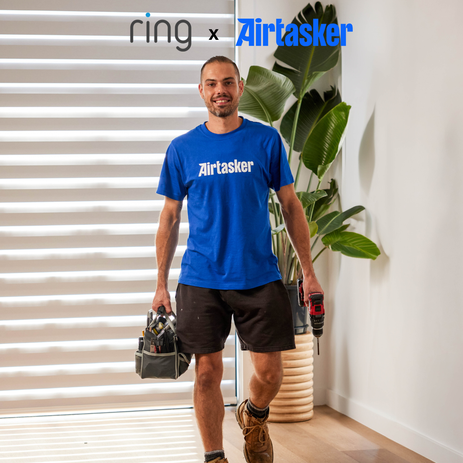Wired Video Doorbell Plus (2nd Gen) (Featuring Retinal 2K) - Man standing with Airtasker tshirt on holding bag of tools. Logo on image has Ring x Airtasker. 