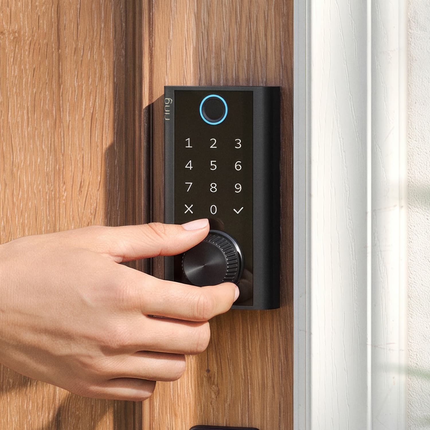 Smart Lock - Hand turning a black smart door lock with illuminated keypad on a wooden door.