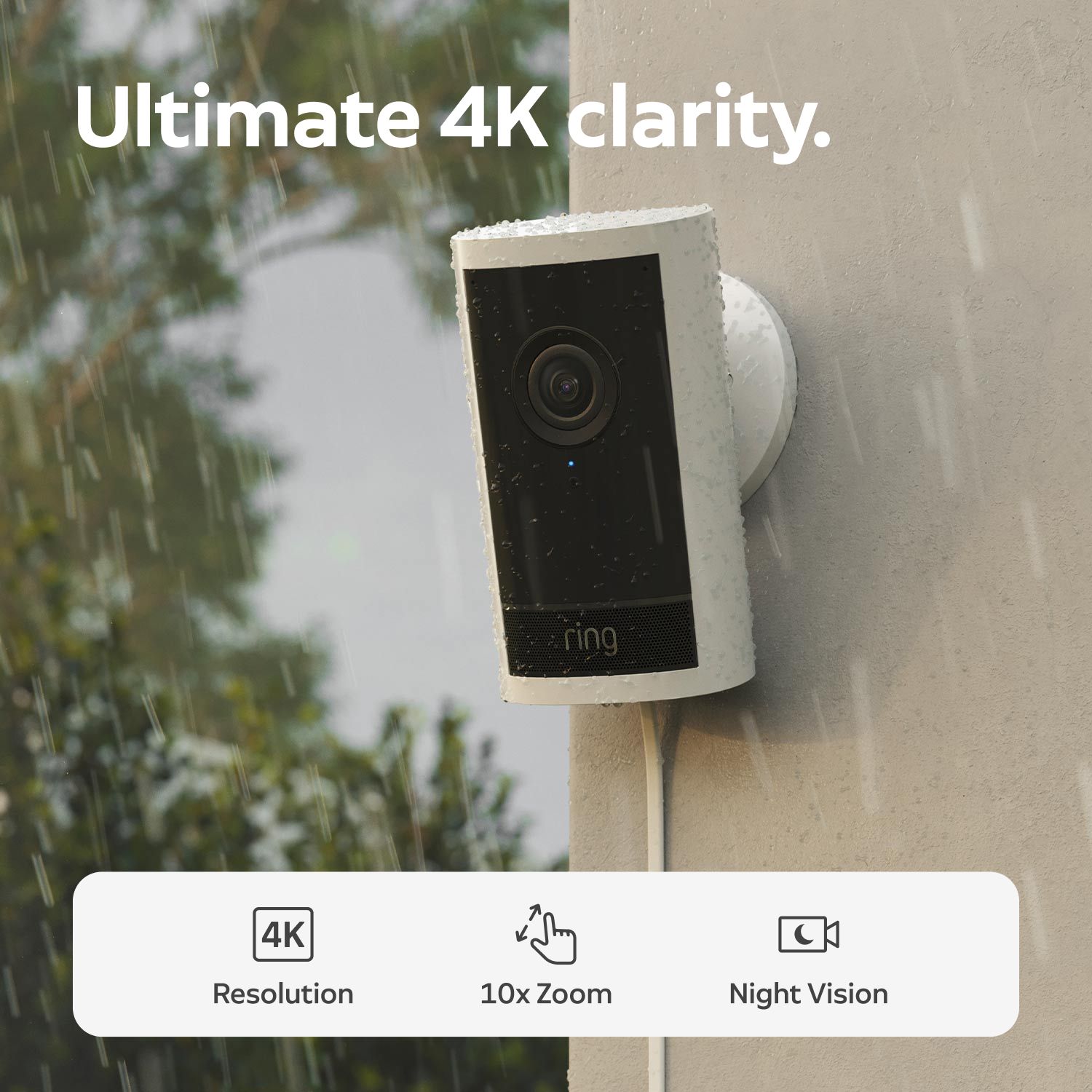 Outdoor Cam 4K Pro - White Ring outdoor camera mounted on a wall in the rain, promoting 4K clarity, 10x zoom, and night vision features.