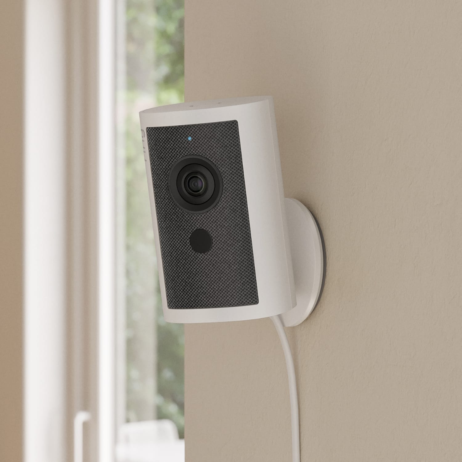 PoE+ to USB-C Indoor Adapter (Indoor Cam 4K, Outdoor Cam 4K Plus, Outdoor Cam 4K Pro, Outdoor Cam Plus) - White indoor security camera with black front panel mounted on a beige wall near a window, power cable hanging down.