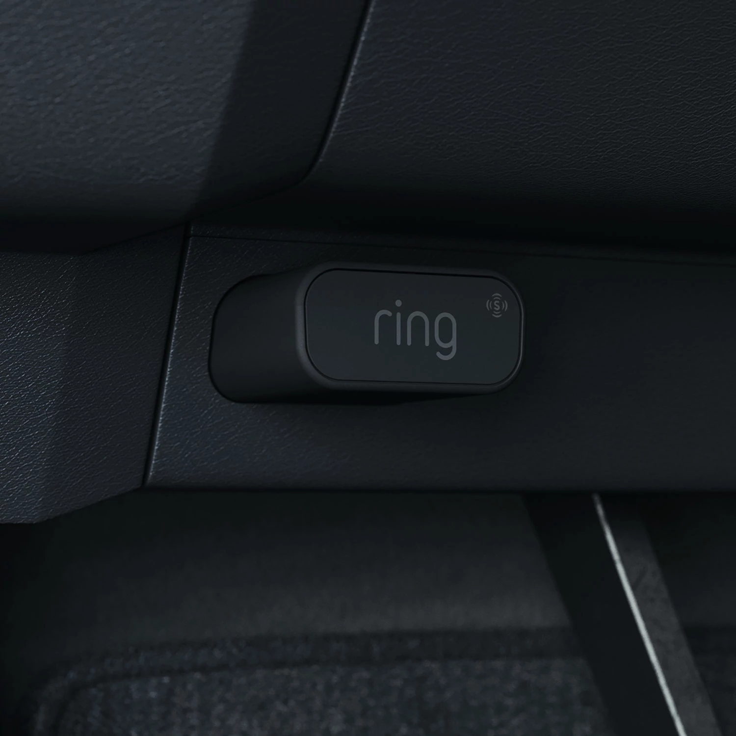 Car Alarm - Black rectangular Car Alarm plugged into OBD 2 port inside car.