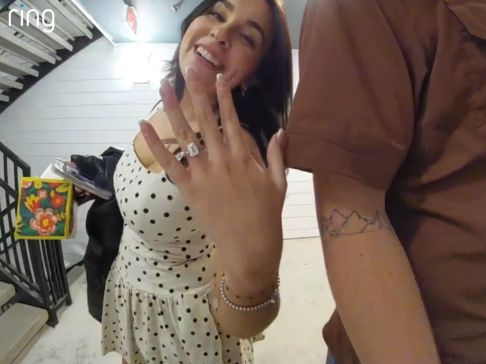 Women smiling showing off her engagement ring at doorbell