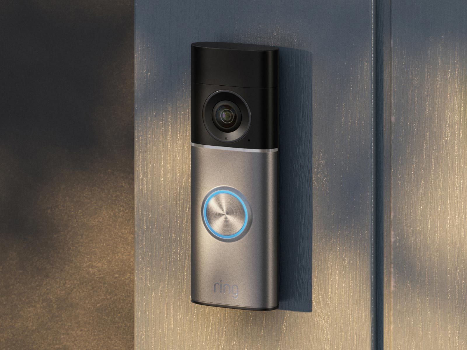 A Deep Silver Wired Doorbell Pro (2nd Gen) is mounted on the wooden siding of a home near the front door. 