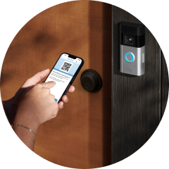 Person pairing a video doorbell with a smartphone at a front door with a round lock nearby.