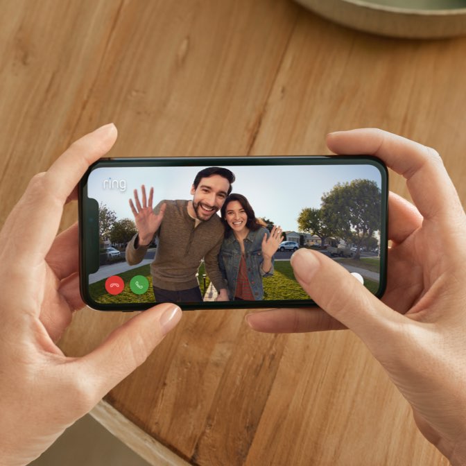 Holding phone with man and woman on screen