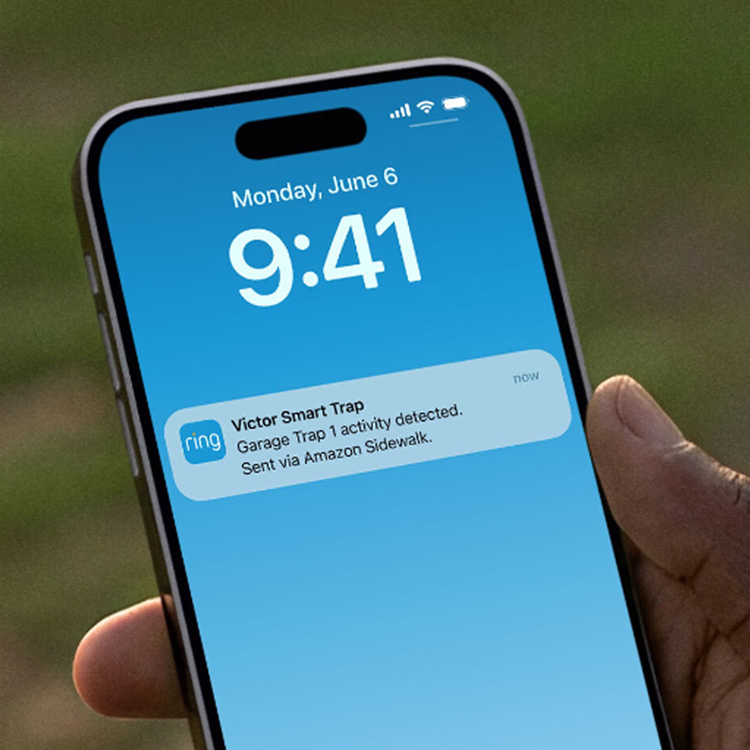 Victor® Smart Rat Trap, Indoor Snap Trap  - Hand holding a smartphone showing a Ring notification “Victor Smart Trap—Garage Trap 1 activity detected,” on a blue lock screen.
