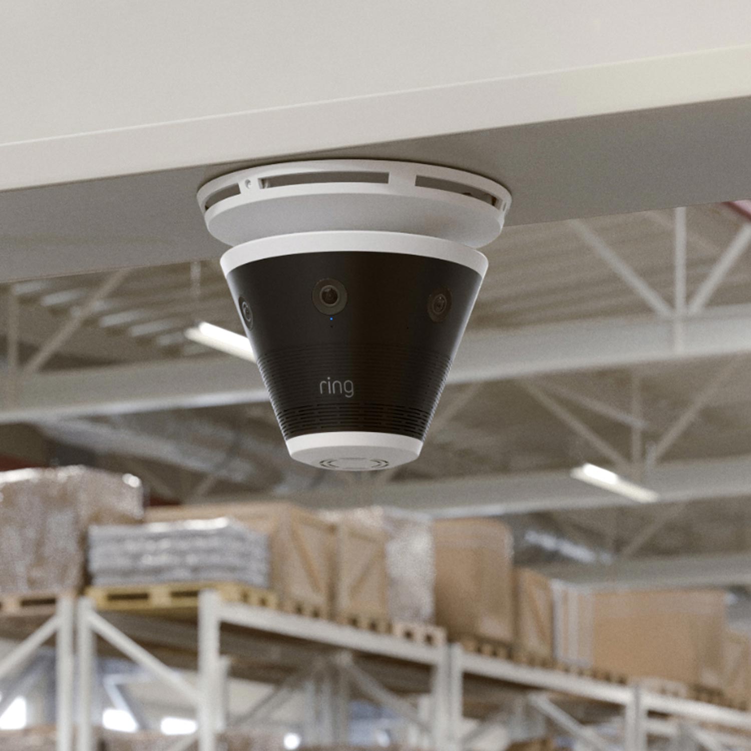 Ring Elite 360 4K - Ceiling-mounted Ring multi-lens security camera in a warehouse with shelves and boxed pallets in the background.