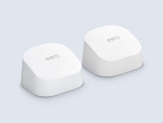 Two white, compact eero 6 Extenders with curved tops and small LED indicator lights on the front.
