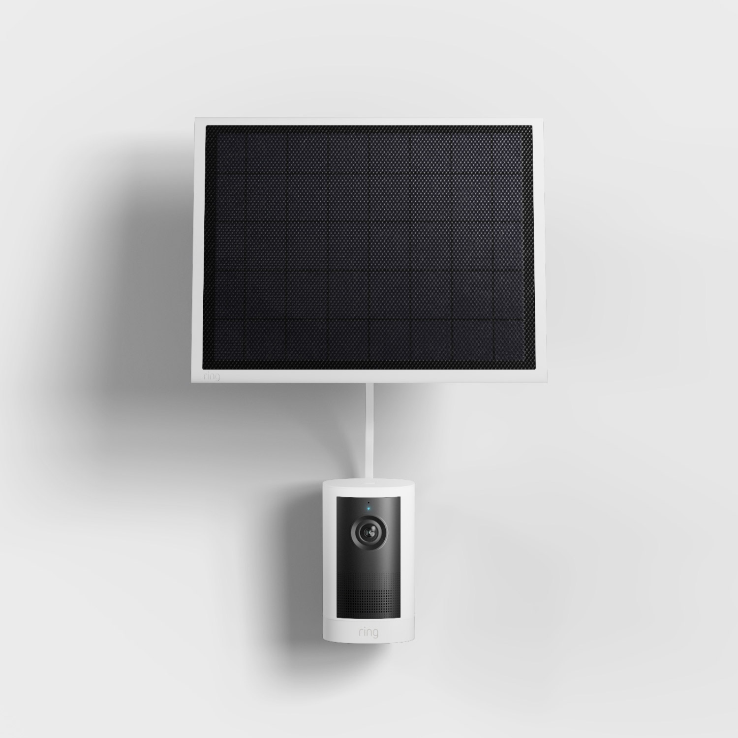 Outdoor Cam 4K Plus  - Solar:White Ring security camera mounted below a square black solar panel on a white wall, connected by a short cable.