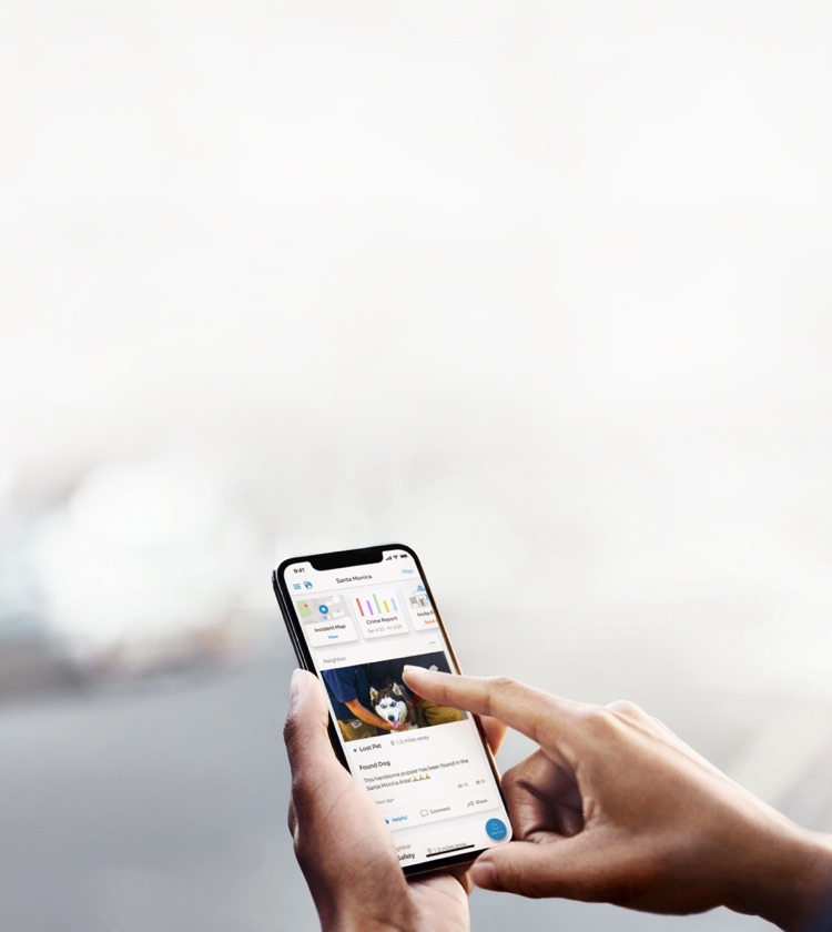 Hand holding smartphone while tapping on an image of a lost pet in the neighbors app.