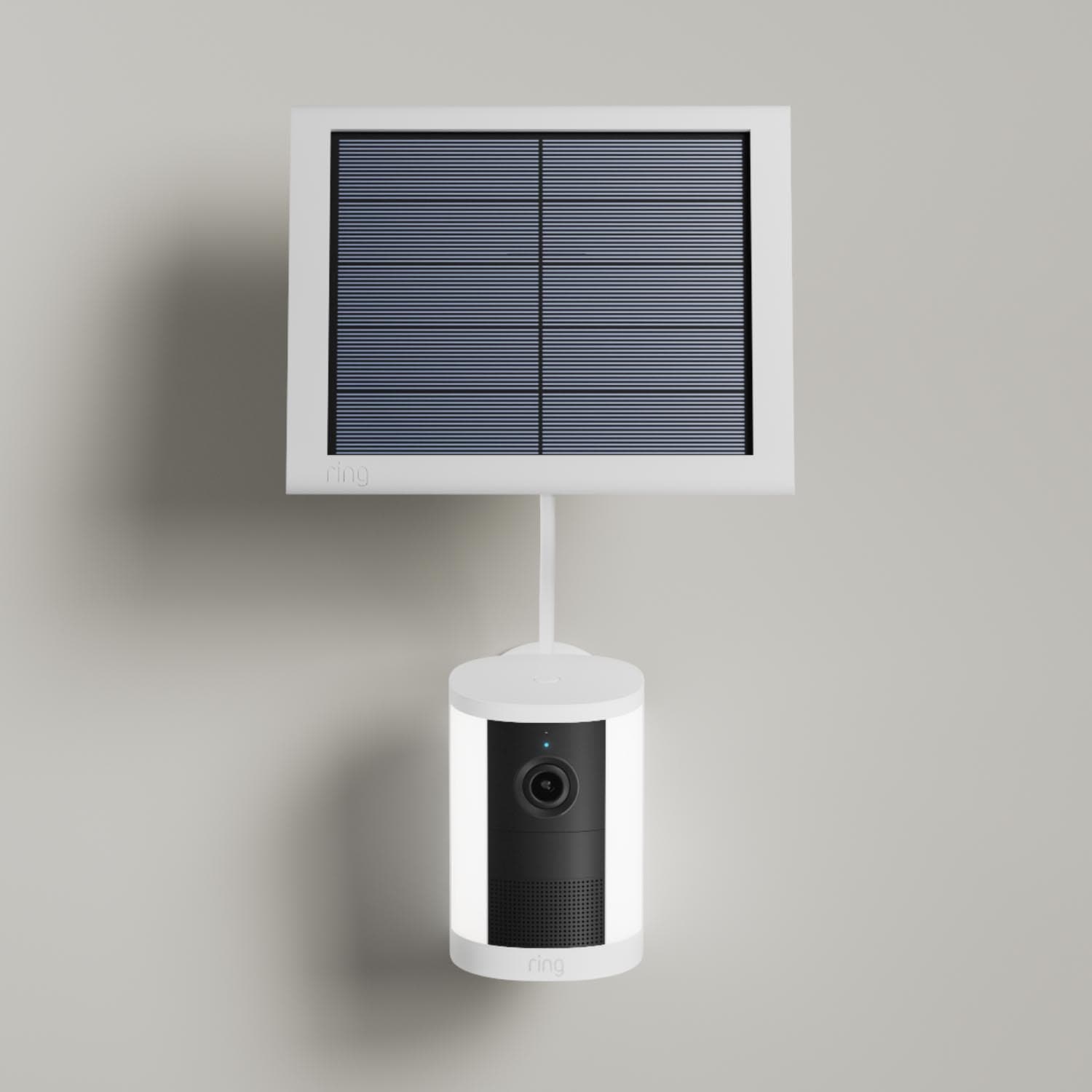 Spotlight Cam (Newest Model) - Solar:White Ring Spotlight Cam (2nd Gen) mounted to a wall with solar panel connected on a gray wall.