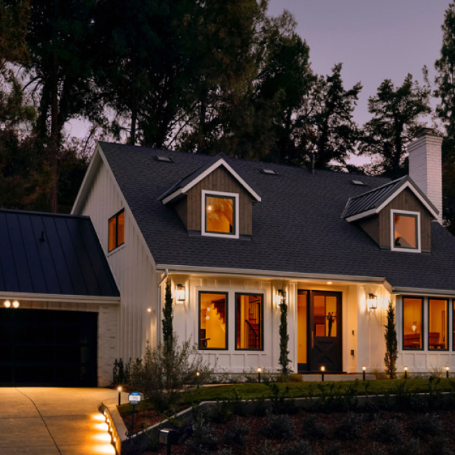 Modern home at dusk with outdoor pathway and garden lights illuminated, showcasing Ring smart lighting features.