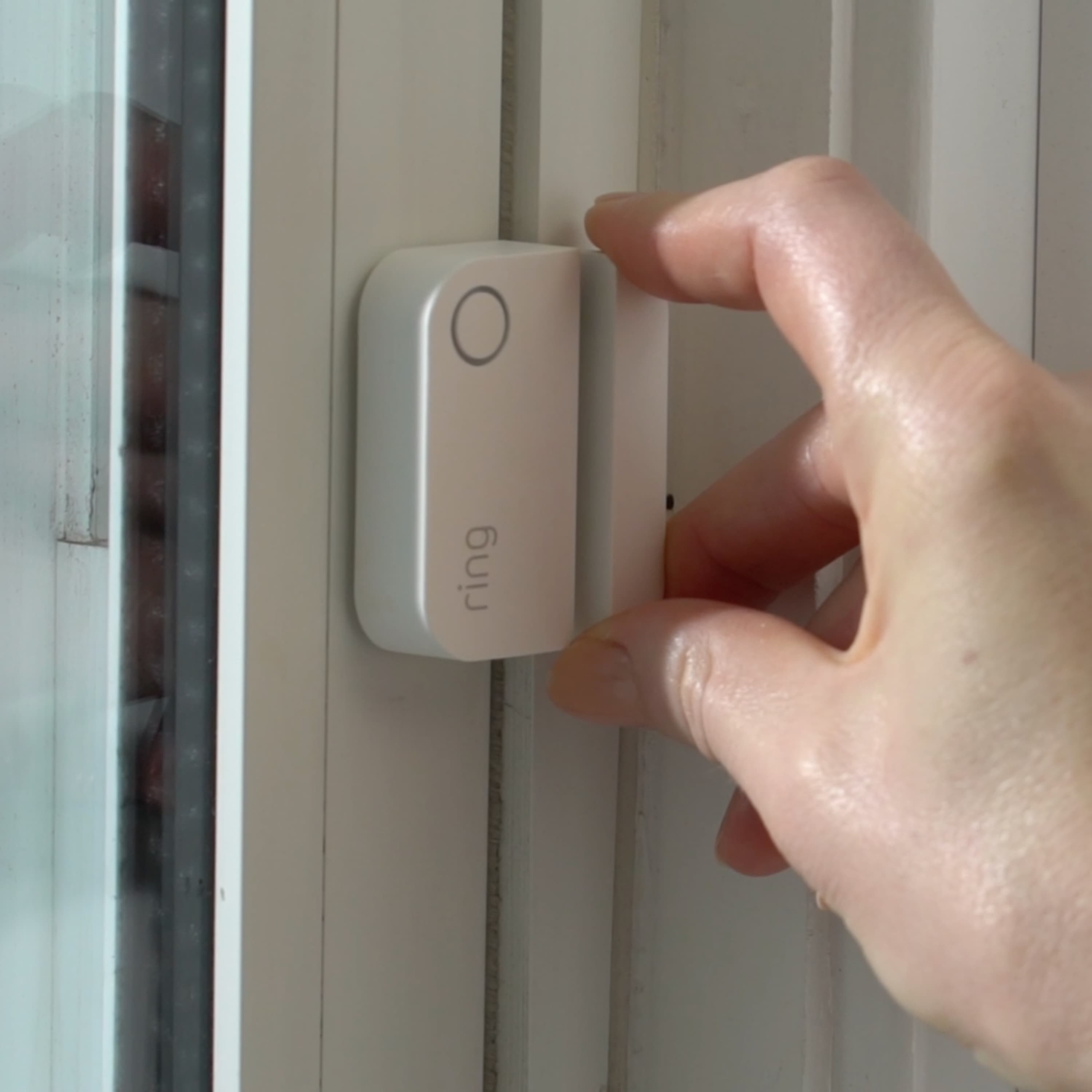 Alarm Window and Door Contact Sensor - Close-up of a hand installing an Alarm Window and Door Contact Sensor.