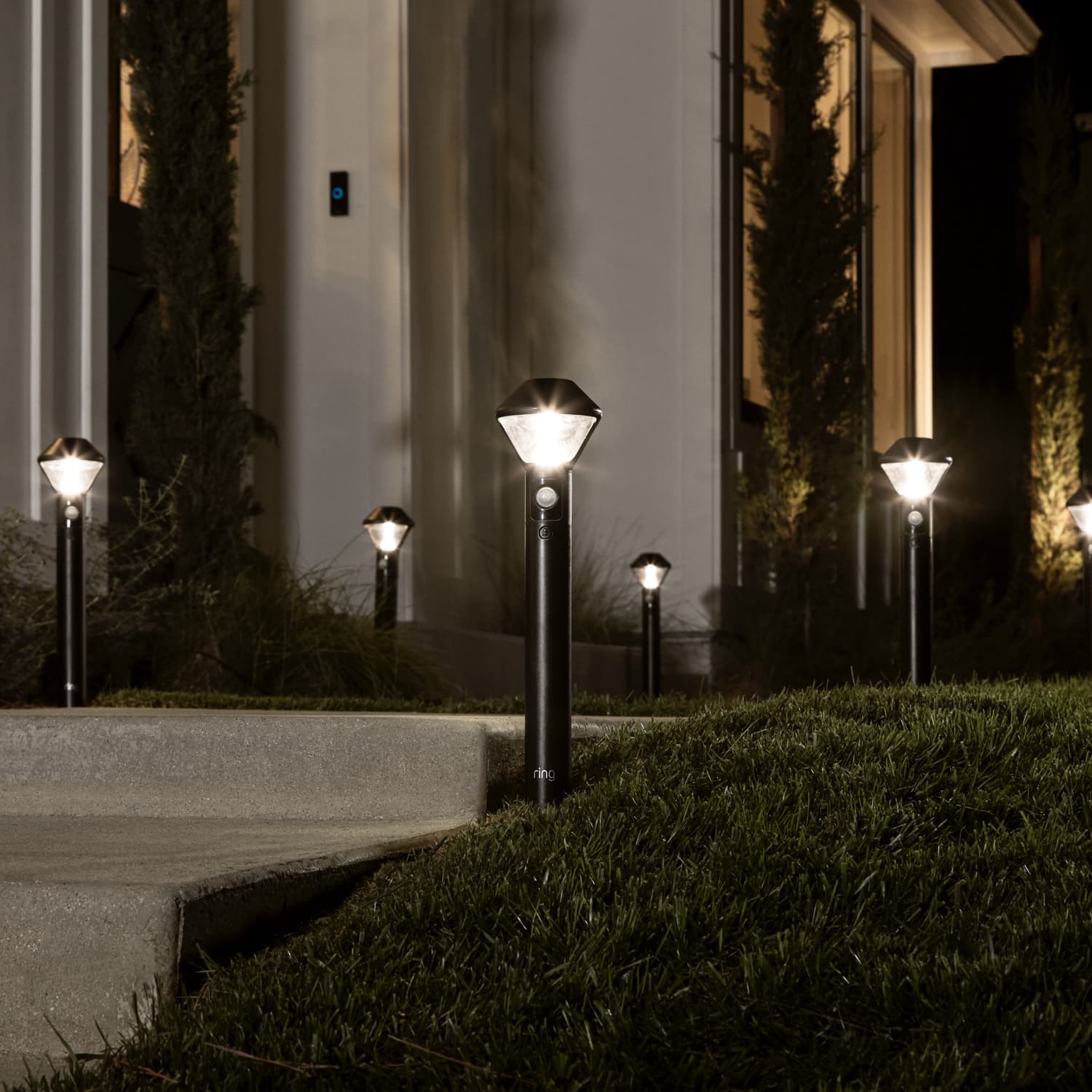 Smart Lighting Solar Pathlight - Outdoors at night, several Pathlights illuminate the walkway to the front door of a home.