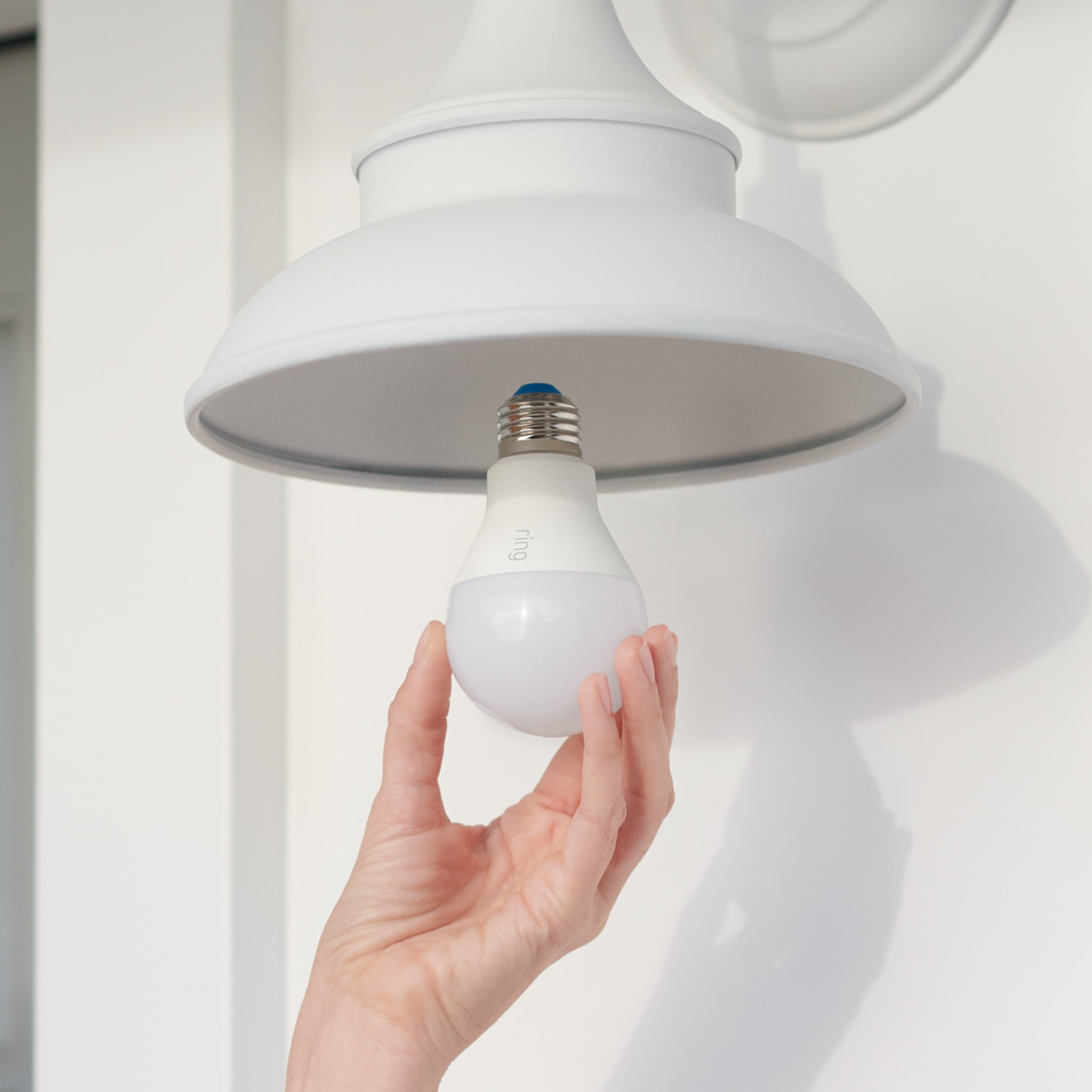 Smart Lighting A19 Smart LED Bulb - Close-up of hand installing A19 Smart LED light bulb into an outdoor light fixture.