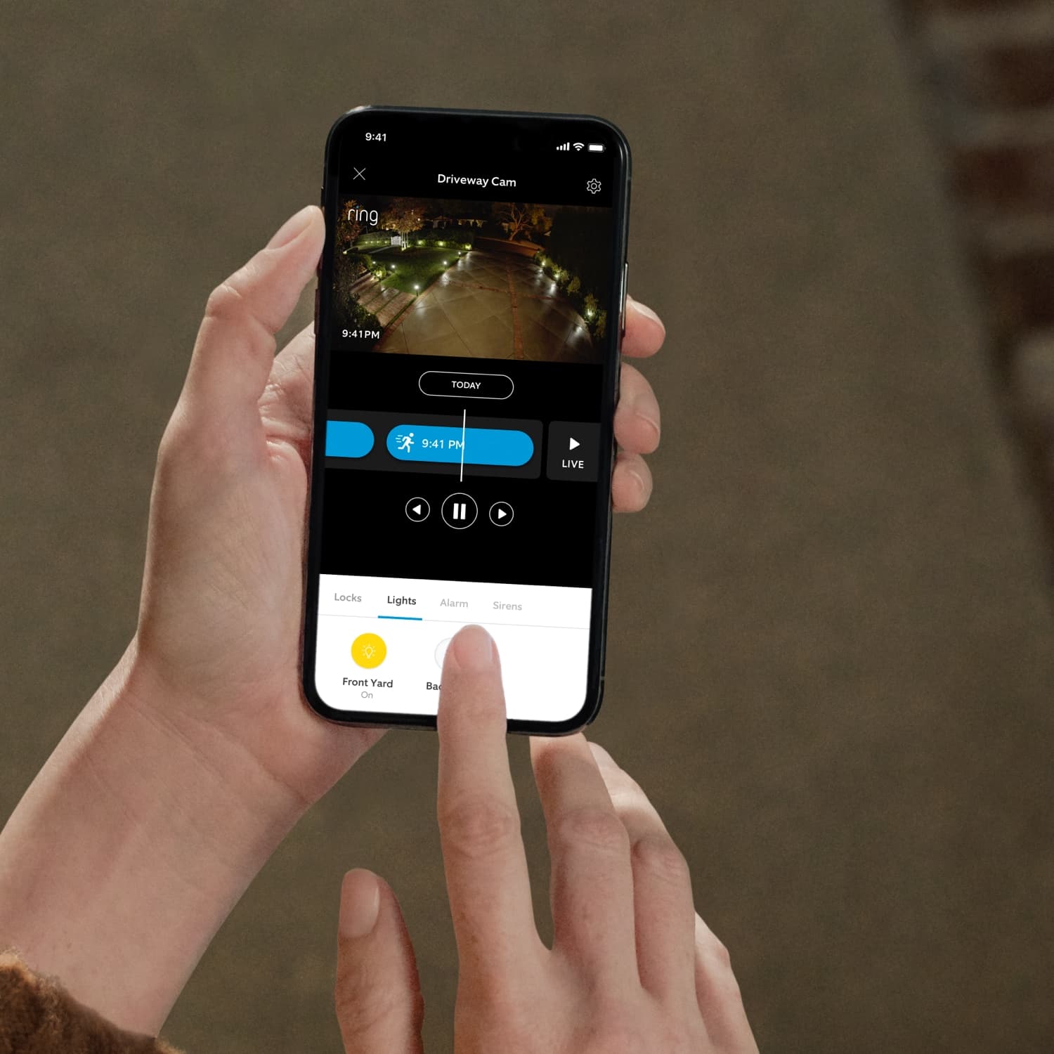 Smart Lighting A19 Smart LED Bulb - Hand holding smartphone while tapping the light settings for the driveway in the Ring app.