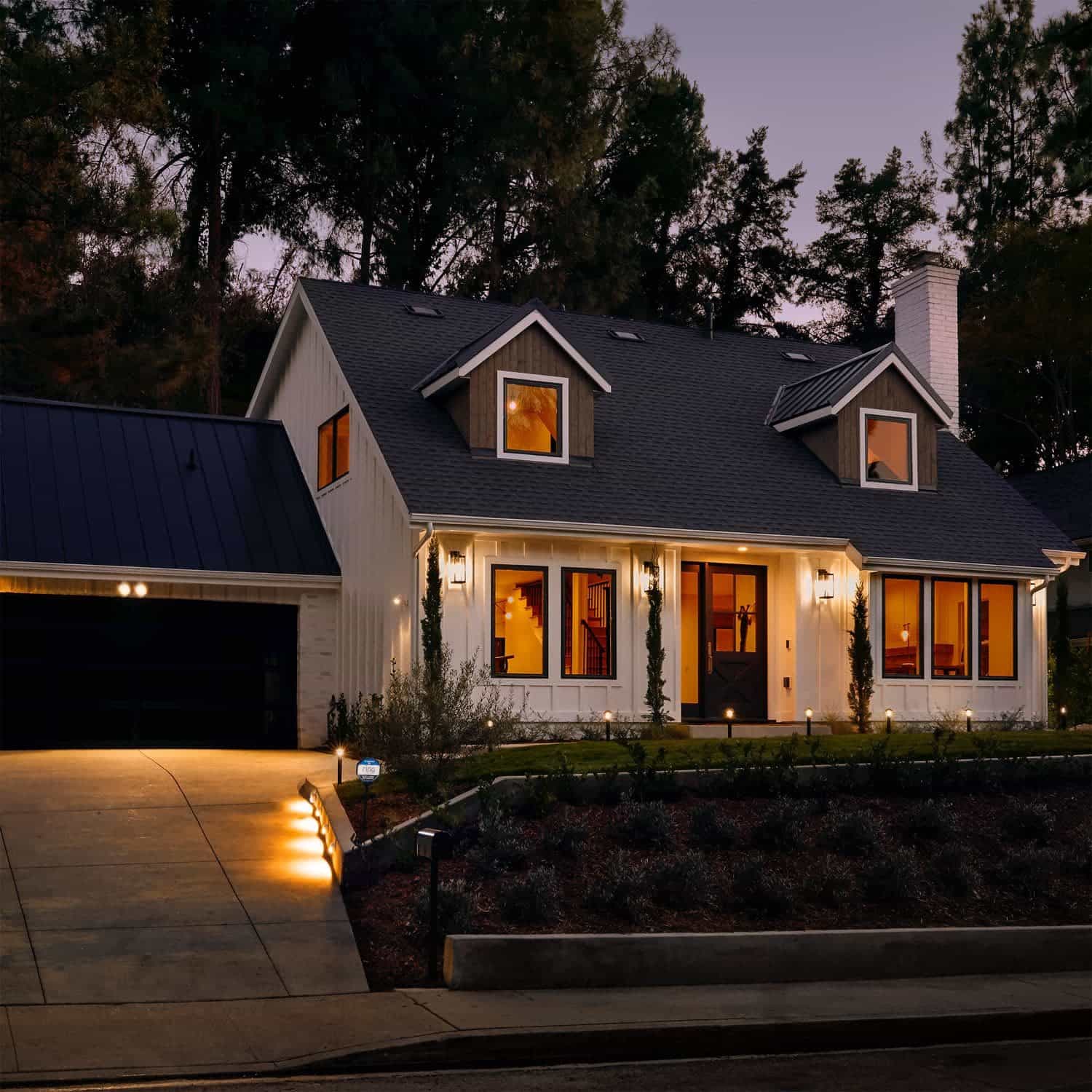 Smart Lighting Pathlight Battery - Outside at dusk, a home is illuminated with an assortment of lights, including several Pathlight Battery lights.