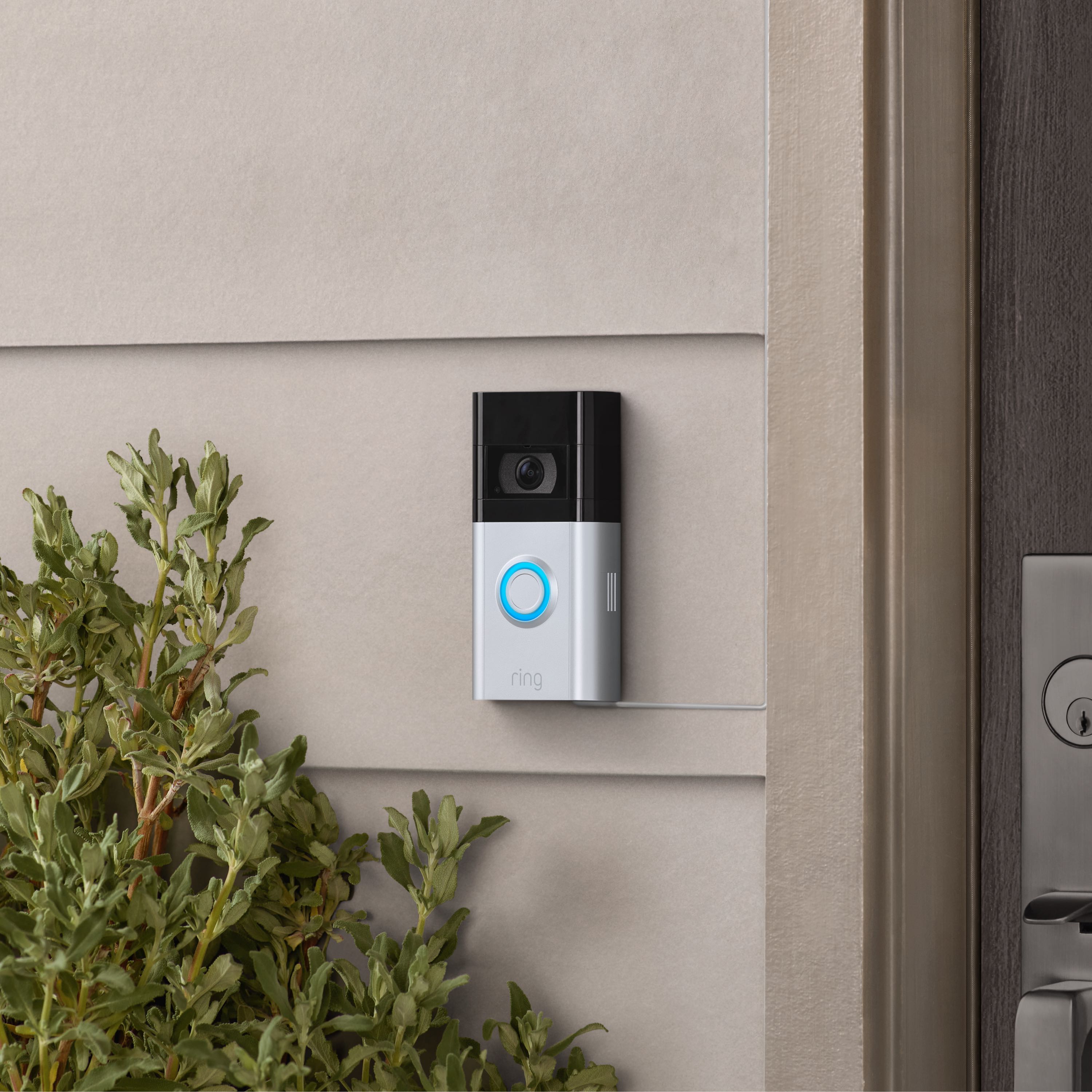 Charging Station + 2 Quick Release Battery Packs - Video Doorbell, 2nd Generation with satin nickel finish mounted to exterior wall of home next to front door.
