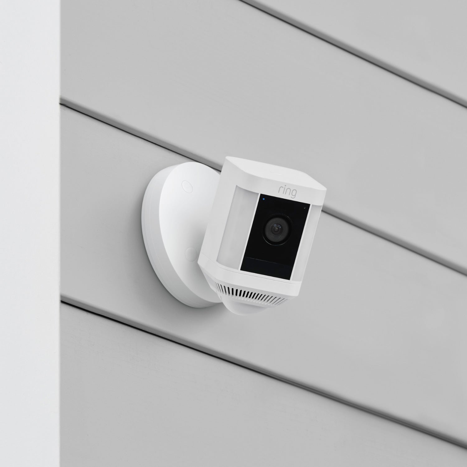 Spotlight Cam Plus (Wired) - Spotlight Cam Plus, Wired model in white, mounted on exterior wall of home.