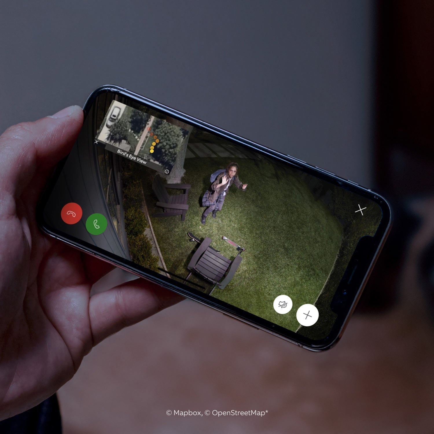 2-Pack Spotlight Cam Pro (Plug-In) - Close-up of smartphone showing video of a person in a yard, looking up into Spotlight Cam Pro camera. Inset is bird's eye view perspective.