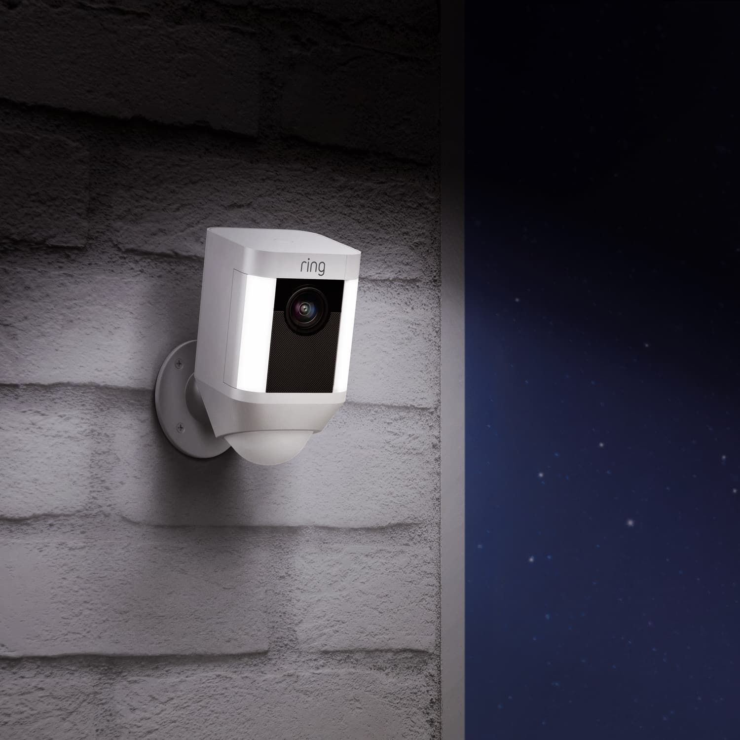 Spotlight Cam Battery (for Certified Refurbished) - Outdoors at night, Spotlight Cam Battery with lights illuminated is mounted to a brick wall.