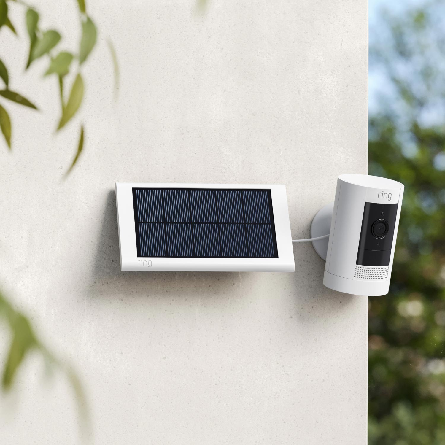 4-Pack Stick Up Cam Solar - Stick Up Cam and small solar panel, both in white, mounted to outside corner of house.