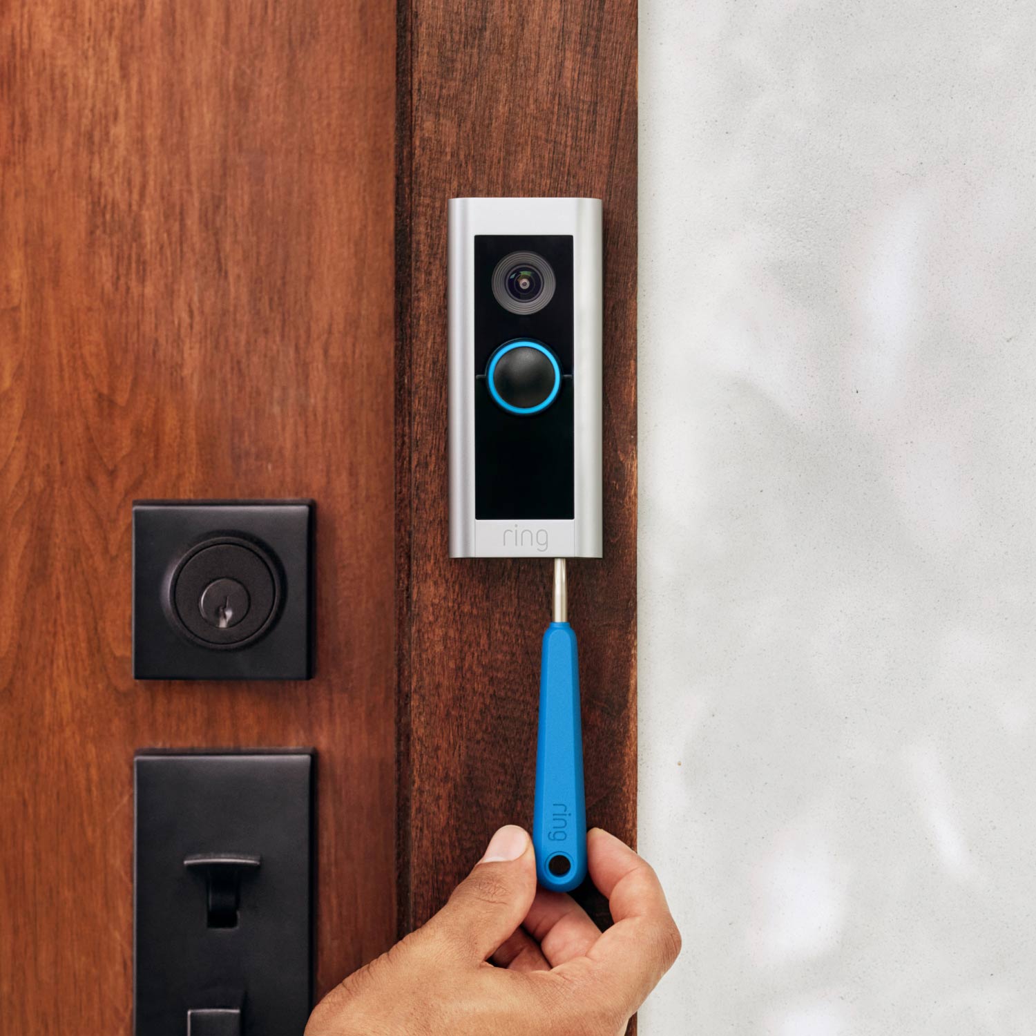 Wired Doorbell Pro (Video Doorbell Pro 2) (Certified Refurbished) - Close-up of hand installing Wired Doorbell Pro in satin nickel finish next to front door.