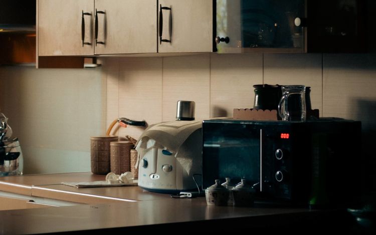 A shot of kitchen appliances on the kitchen counter of a home, including a microwave and a toaster.