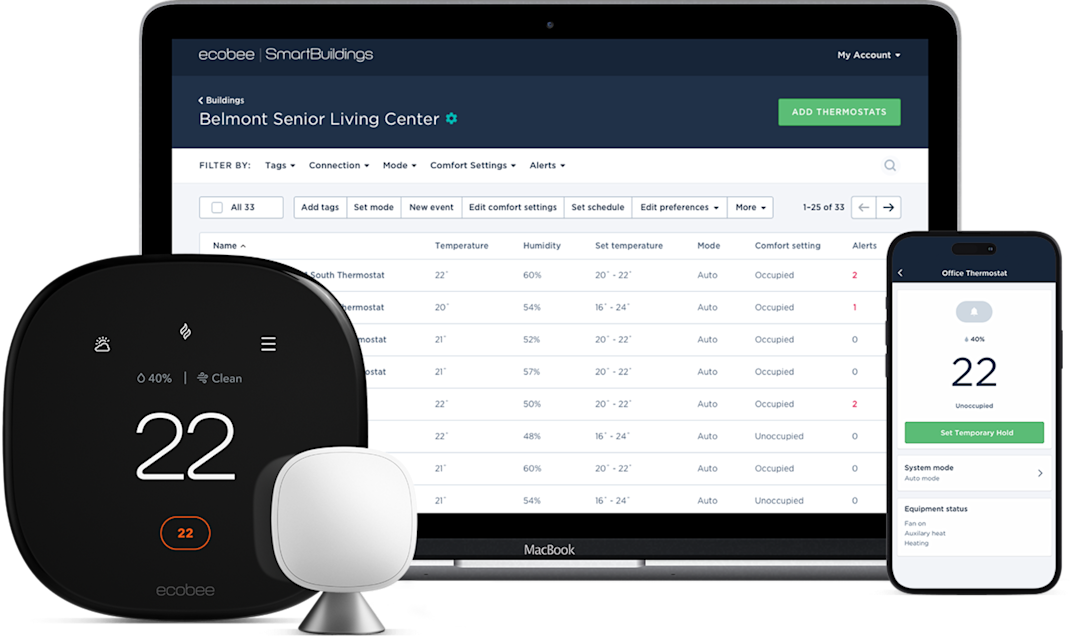 a computer and phone showing the ecobee "my buildings" dashboard, with a thermostat