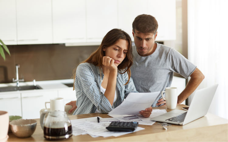 Concerned couple looking at bills.