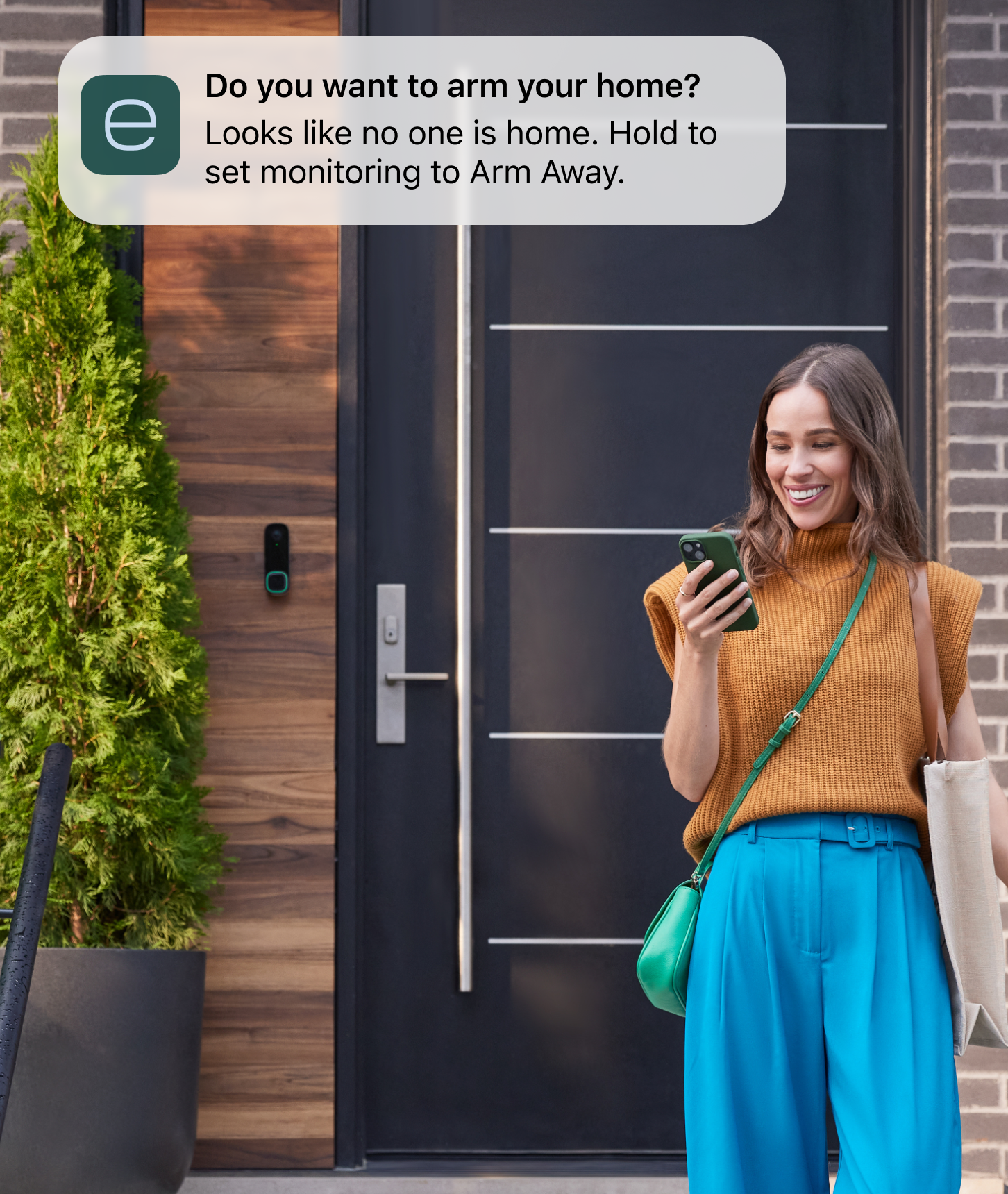 ecobee smart doorbell camera on a house, a woman looks at her phone and sees a notification from the ecobee app