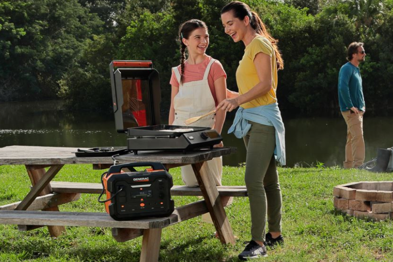 People use an electric grill outdoors powered by the GB1000