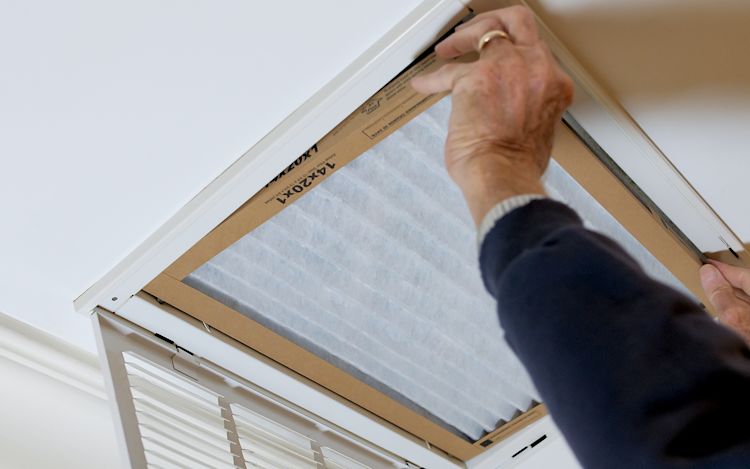 Person changing a disposable filter.