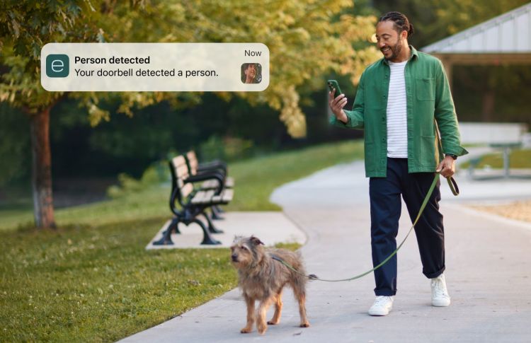 Man walking his dog, receiving Smart Doorbell Camera notification on ecobee app.