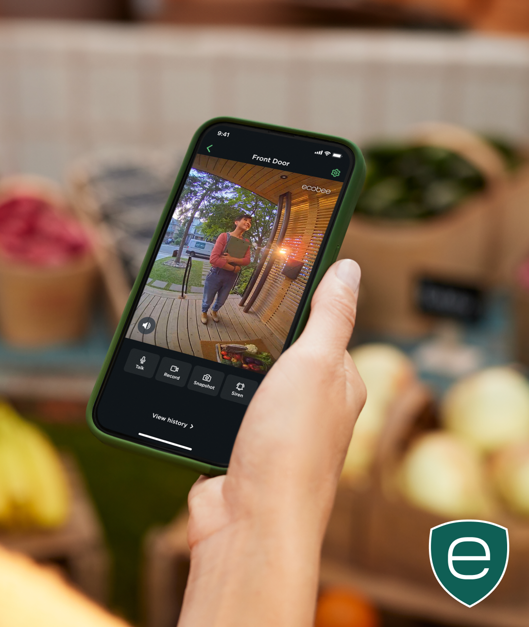 hand holding a phone, screen shows someone at the door via the ecobee app