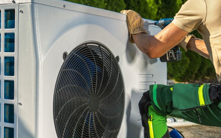 Heat pump technician working to install heat pump.