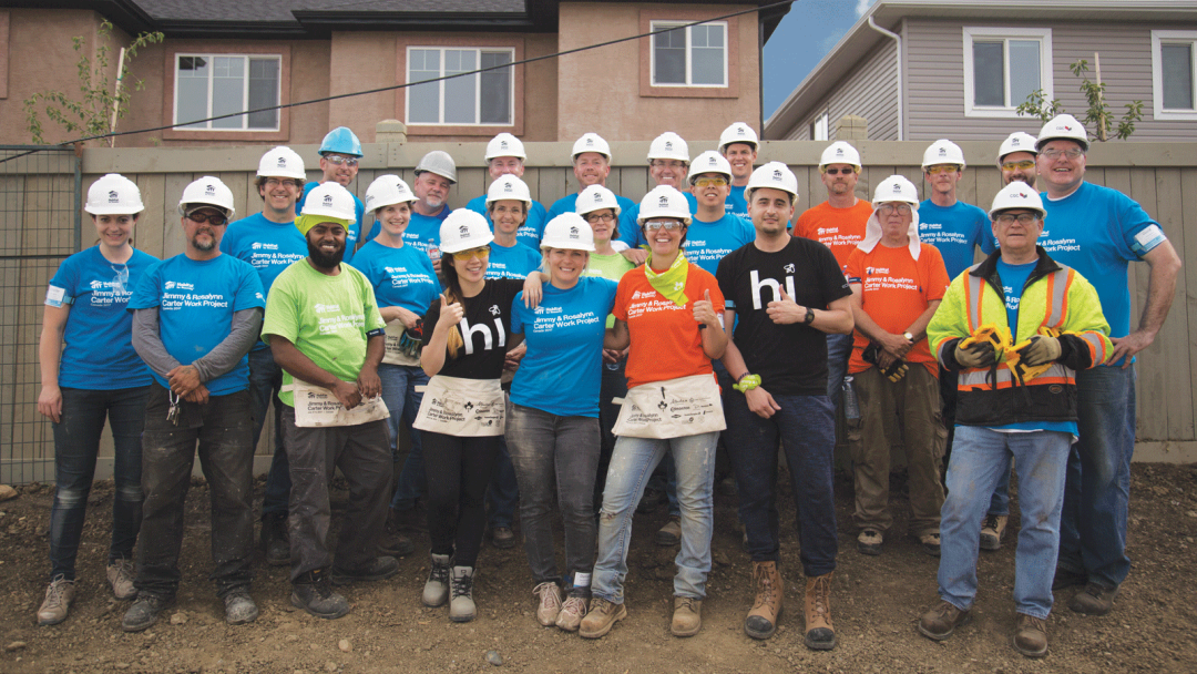 Group of volunteers, including ecobee employees, posing for a group picture while taking a break from building homes. 