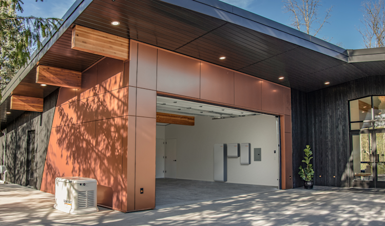 Generac PWRcell 2 battery charging panels shown in a modern home's garage with a Generac generator on the side of the house.