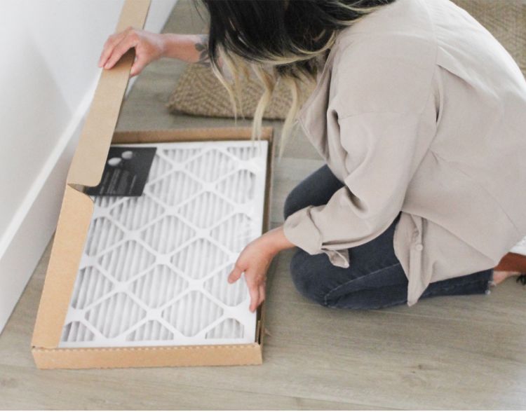 A woman opens up an ecobee air filter from a box.