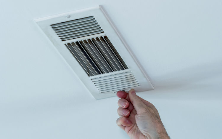 Homeowner adjusting ceiling vent