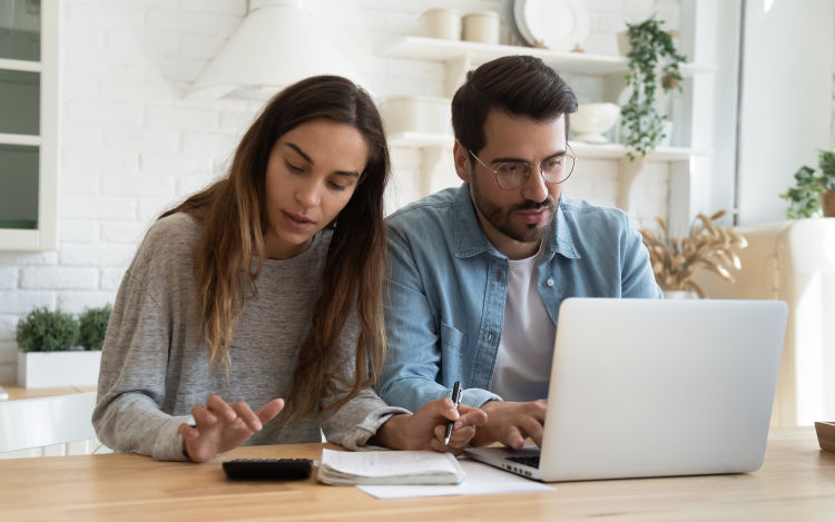 Couple on a laptop budgeting.