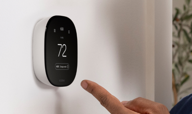 ecobee thermostat on a wall with a hand pointing at it
