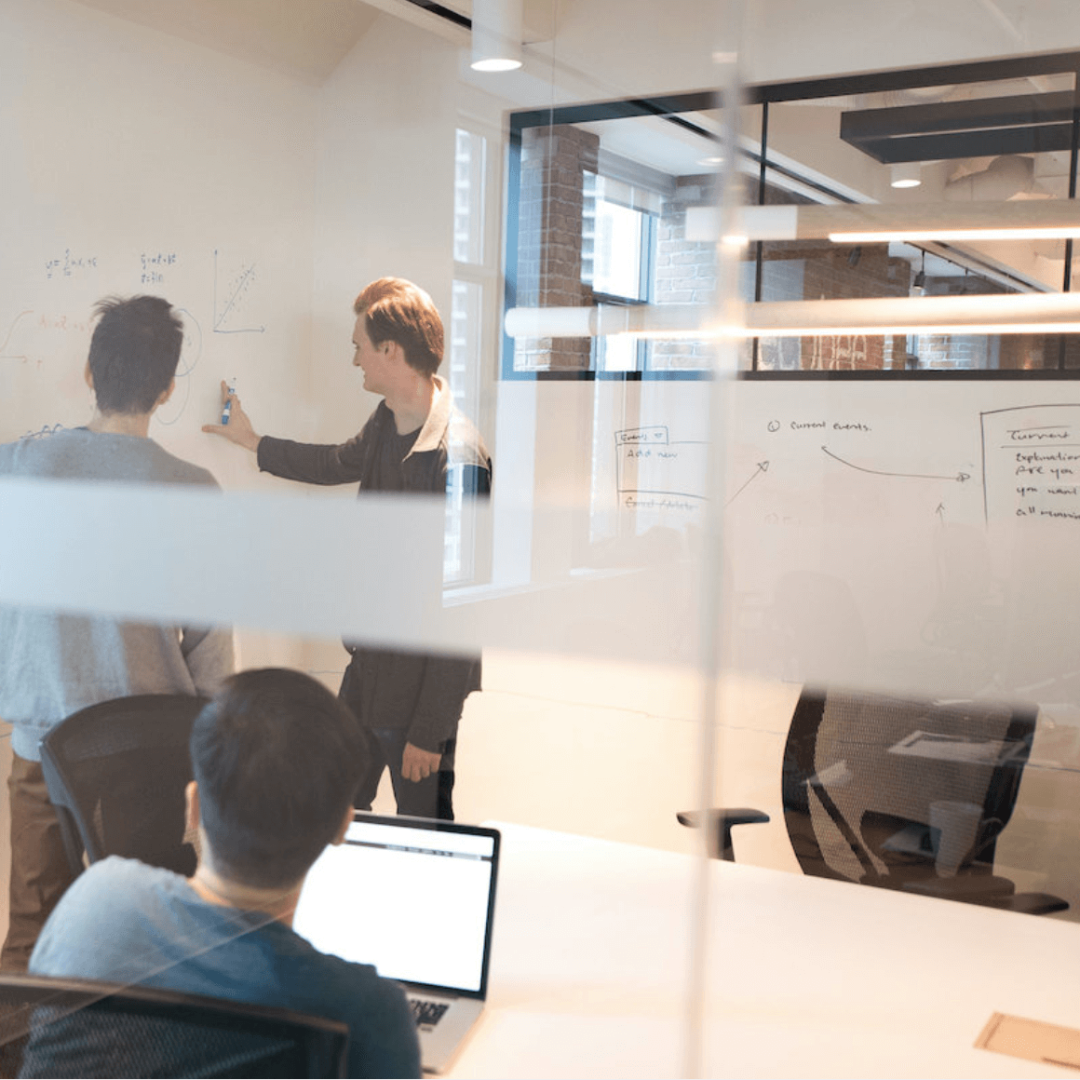   Startup entrepreneurs working together on a whiteboard in a coworking space.