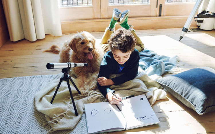  "Good boy" dog watches as his brother scribbles in his workbook