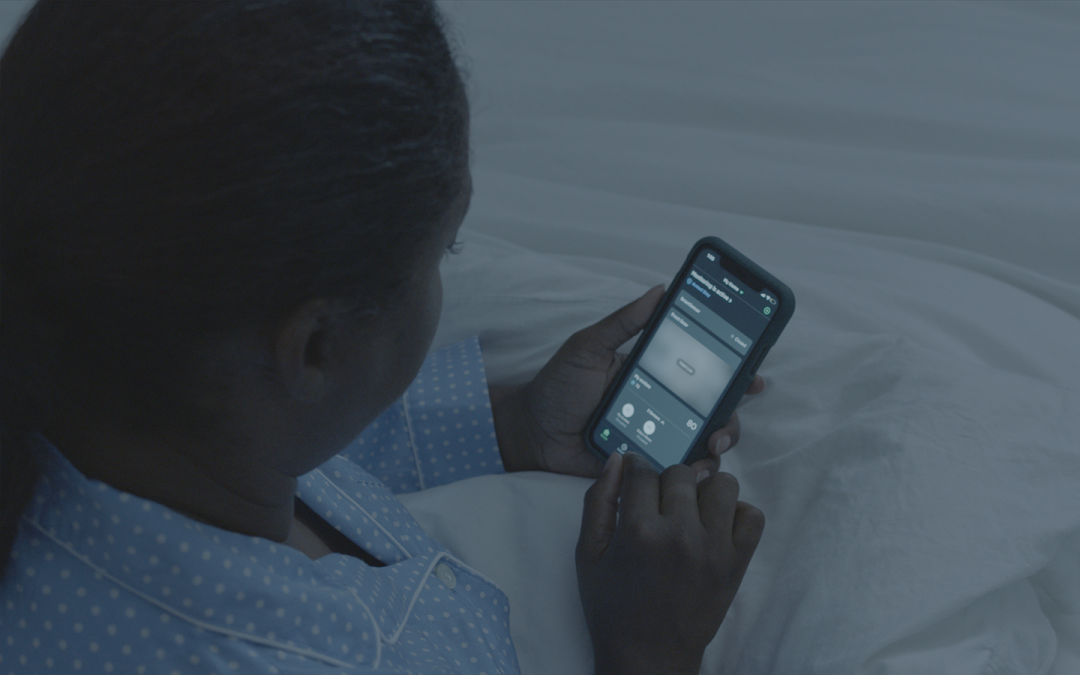 Lady sets the temperature from bed with the ecobee app. 