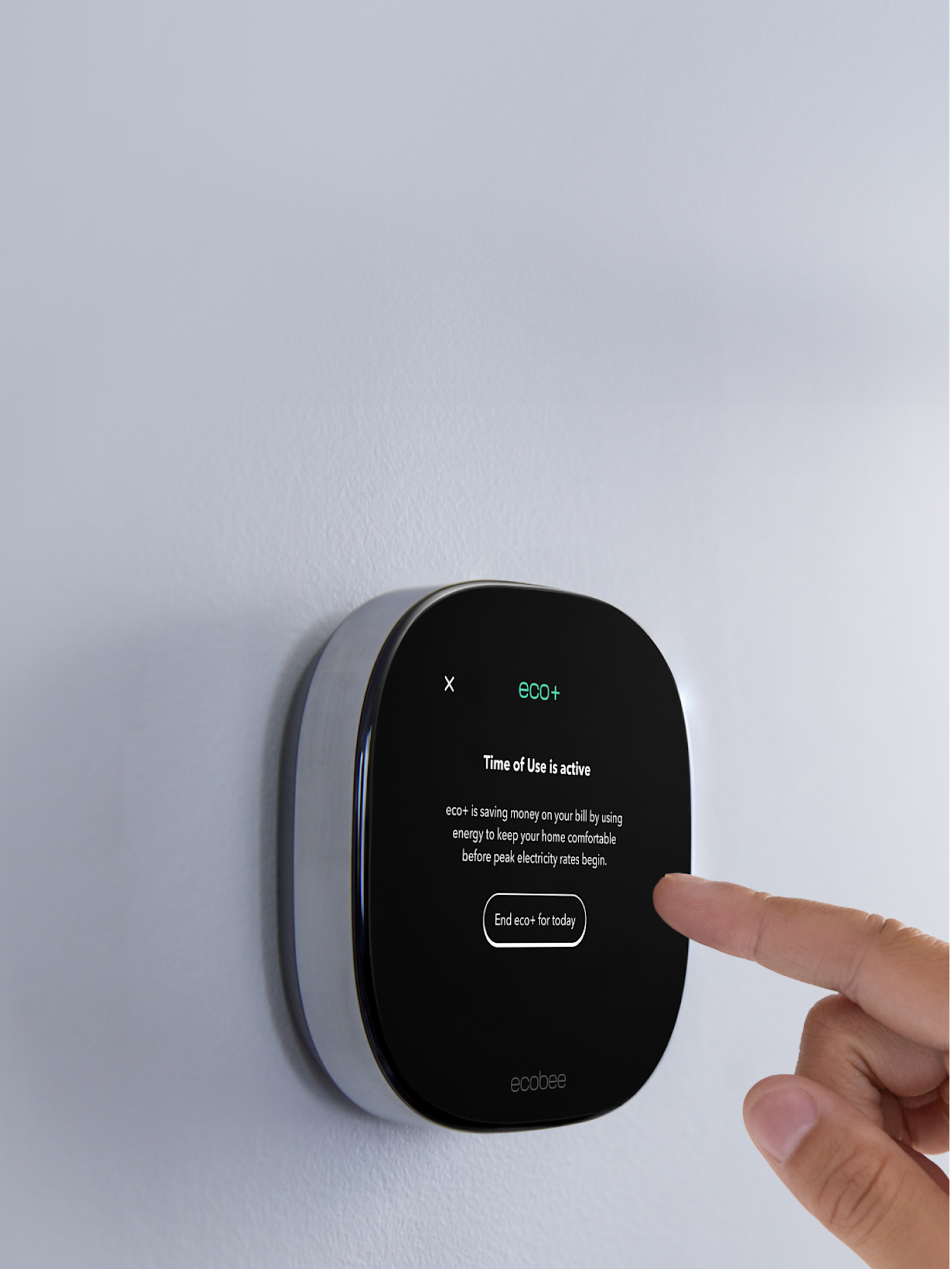 a hand reaching out to touch an ecobee thermostat