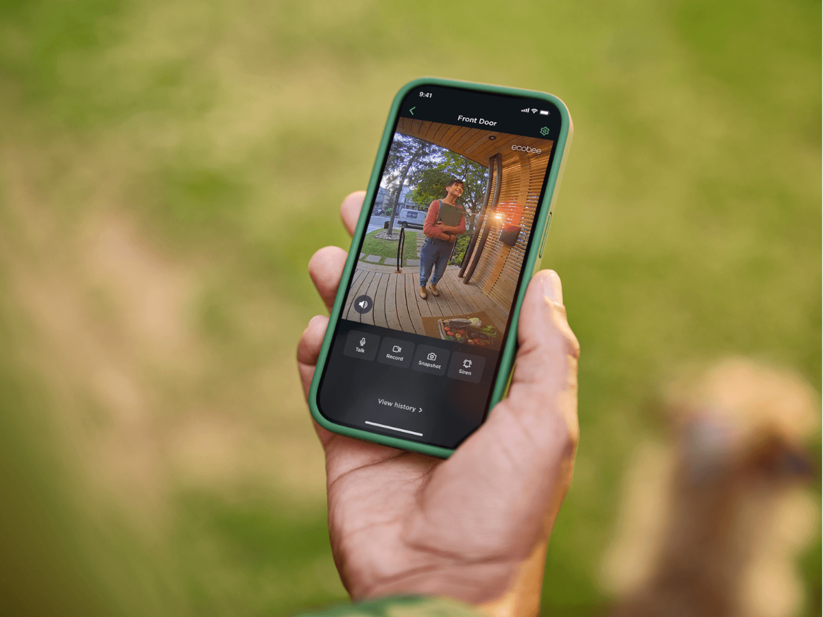 A close-up of a live view of ecobee's Smart Doorbell Camera on a mobile phone and a person is standing at their front door. 