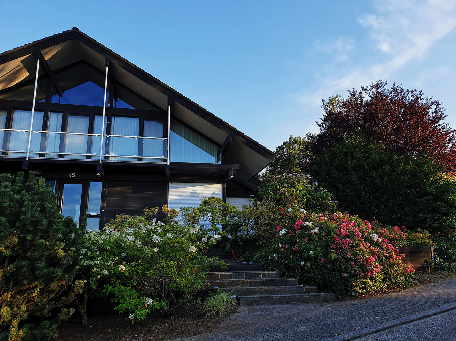 The exterior of a house is surrounded by flowers.